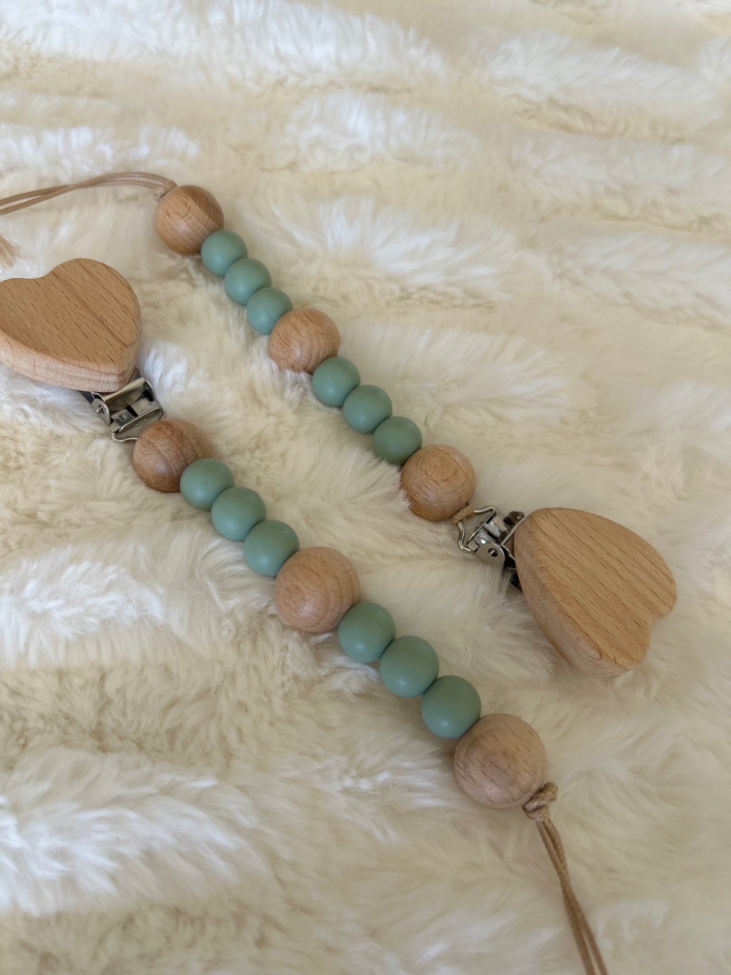 Green pacifier clip with beechwood and food grade silicone beads featuring a wooden heart on clip.