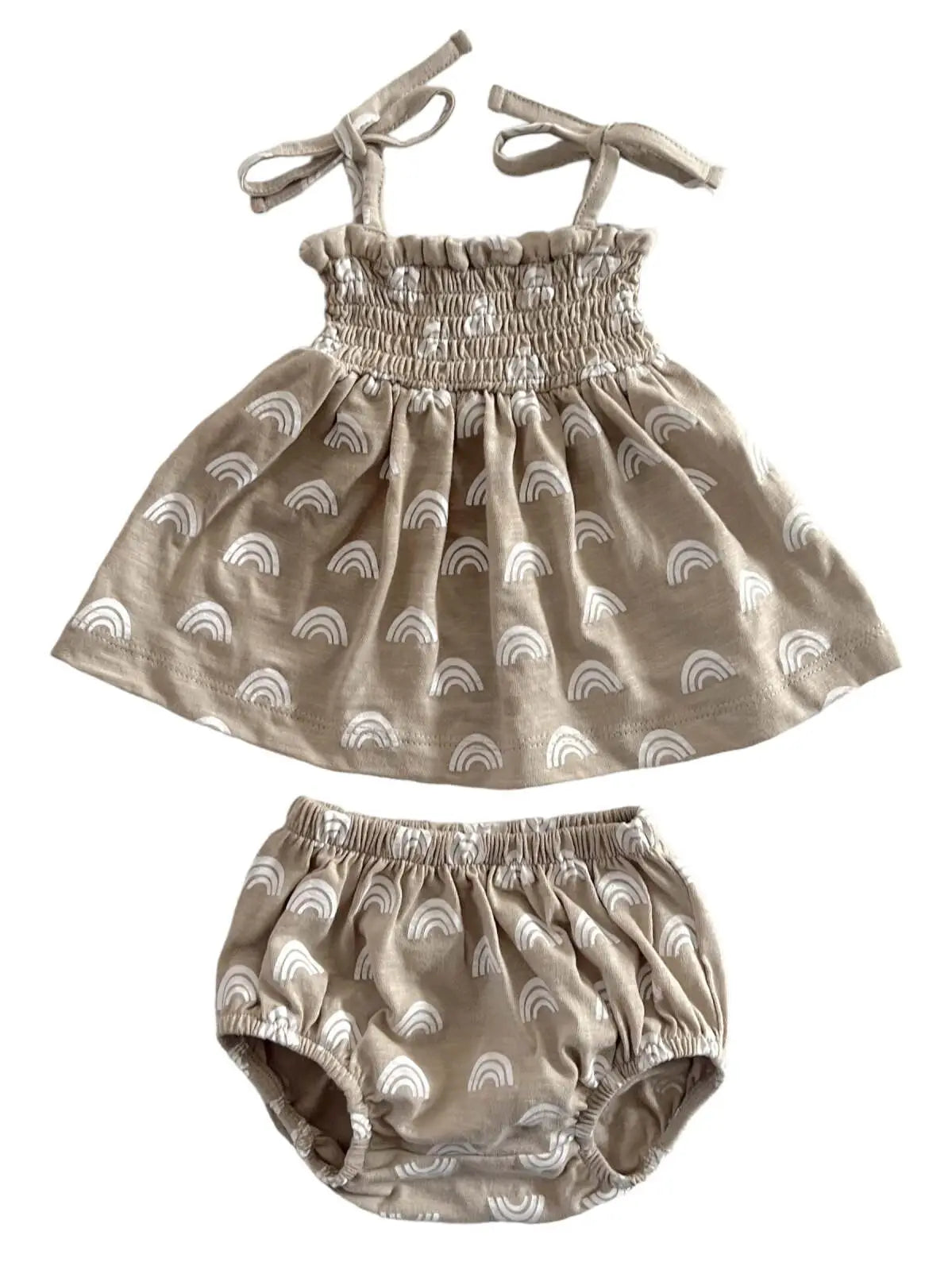 Back of beige colored baby smocked set with rainbow patterns, consisting of a spaghetti strap top and matching bloomers with adjustable straps.