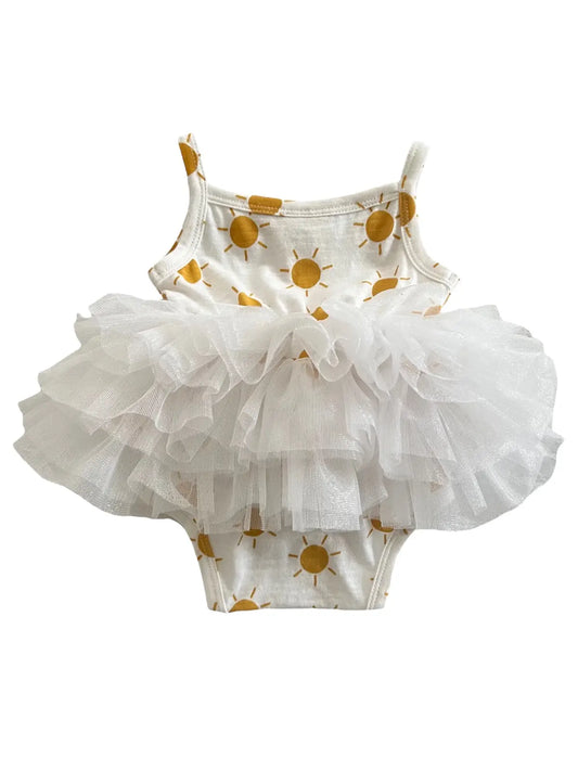A white tutu bodysuit for babies with a floral pattern and ruffled layers.