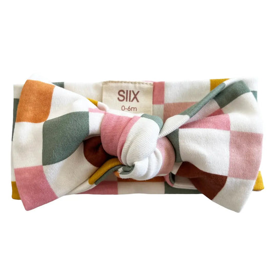 Colorful checkered headband with a bow on a white background
