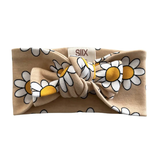 Beige headband with white daisy pattern on a white background