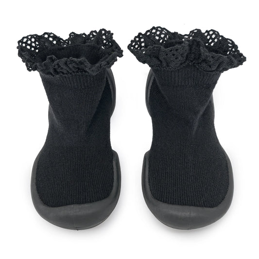 A pair of black Komuello First Walker Baby Sock Shoes with lace trim on the top and a non-slip rubber sole.