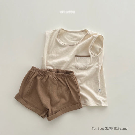 A two-piece outfit set for toddlers, consisting of a sleeveless beige top with a pocket and matching brown shorts with an elastic waistband.